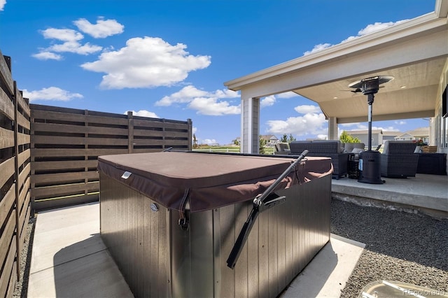 view of patio / terrace with a hot tub and fence