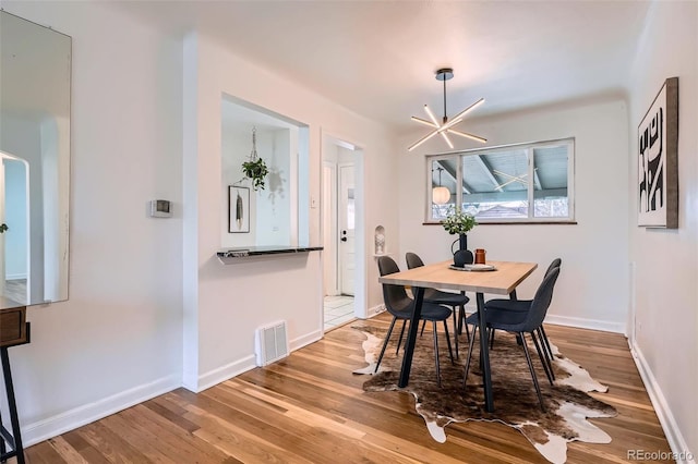 dining area with a notable chandelier and light wood-type flooring