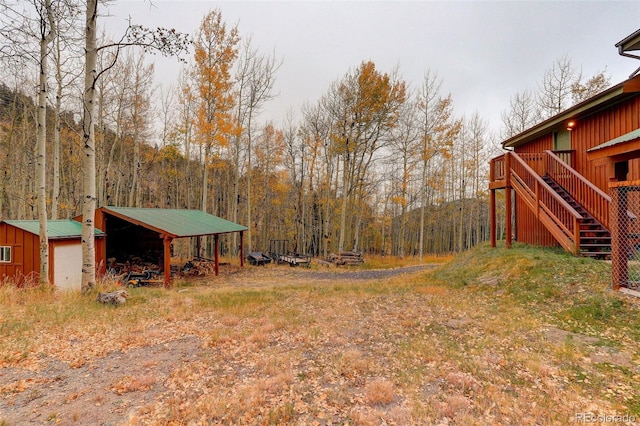 2720 S Spring Gulch Rd, Idaho Springs, CO 80452 - view of yard with an outdoor structure, a view of trees, and stairs