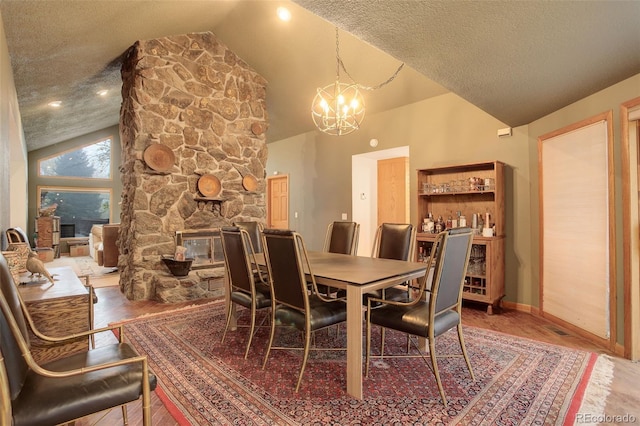 2720 S Spring Gulch Rd, Idaho Springs, CO 80452 - dining room with a chandelier, a fireplace, baseboards, a textured ceiling, and wood finished floors
