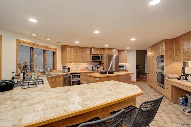 2720 S Spring Gulch Rd, Idaho Springs, CO 80452 - kitchen with stainless steel appliances, recessed lighting, a sink, tasteful backsplash, and a kitchen breakfast bar
