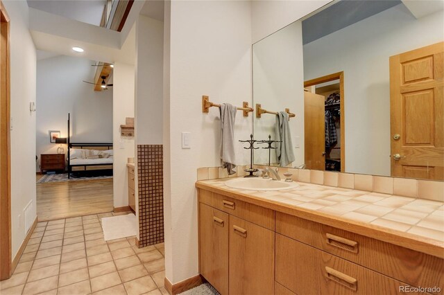 2720 S Spring Gulch Rd, Idaho Springs, CO 80452 - full bathroom featuring ensuite bath, vanity, a spacious closet, tile patterned floors, and baseboards