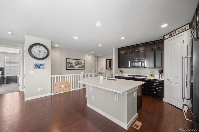 398 Midden Pl, Castle Rock, CO 80104 - kitchen featuring appliances with stainless steel finishes, dark wood-type flooring, light countertops, a kitchen island with sink, and recessed lighting