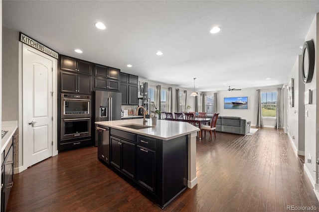 398 Midden Pl, Castle Rock, CO 80104 - kitchen featuring appliances with stainless steel finishes, light countertops, dark wood-type flooring, open floor plan, and recessed lighting