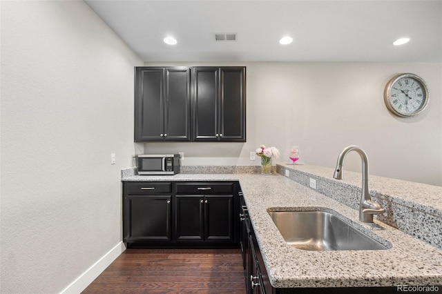 398 Midden Pl, Castle Rock, CO 80104 - kitchen with stainless steel microwave, dark wood-style floors, light stone counters, recessed lighting, and dark cabinetry