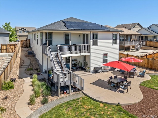 398 Midden Pl, Castle Rock, CO 80104 - rear view of property with stairway, a fenced backyard, solar panels, a patio area, and a shingled roof