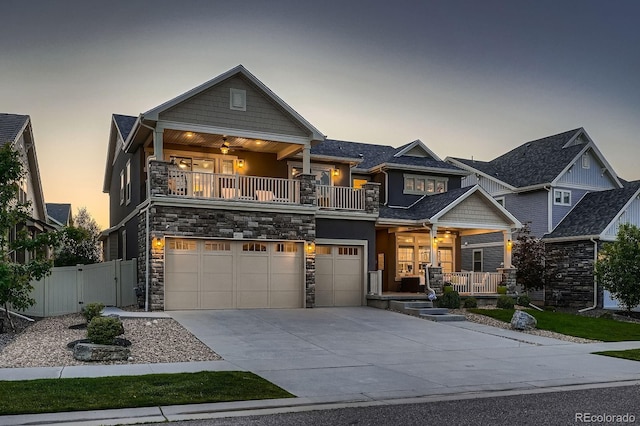 4965 Malaya St, Denver, CO 80249 - craftsman inspired home featuring a porch, a balcony, concrete driveway, a garage, and stone siding