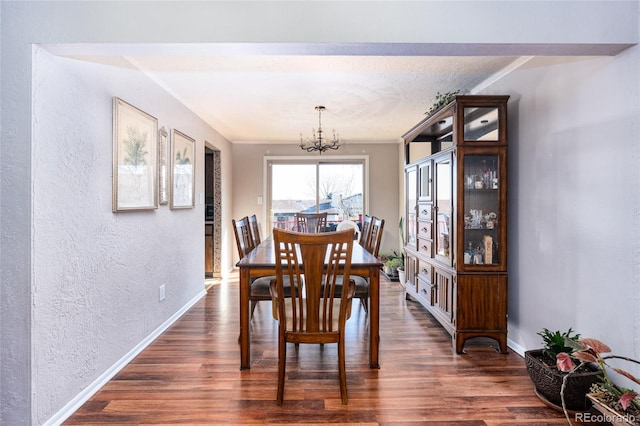 dining space with an inviting chandelier, a textured ceiling, and dark hardwood / wood-style flooring