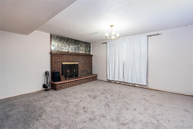 unfurnished living room featuring an inviting chandelier, a fireplace, a textured ceiling, and carpet flooring