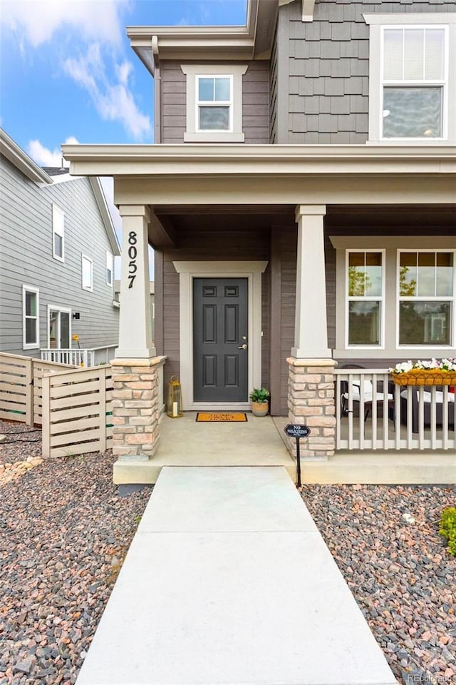 8057 Monte Vista Cir, Littleton, CO 80125 - doorway to property with covered porch and stone siding