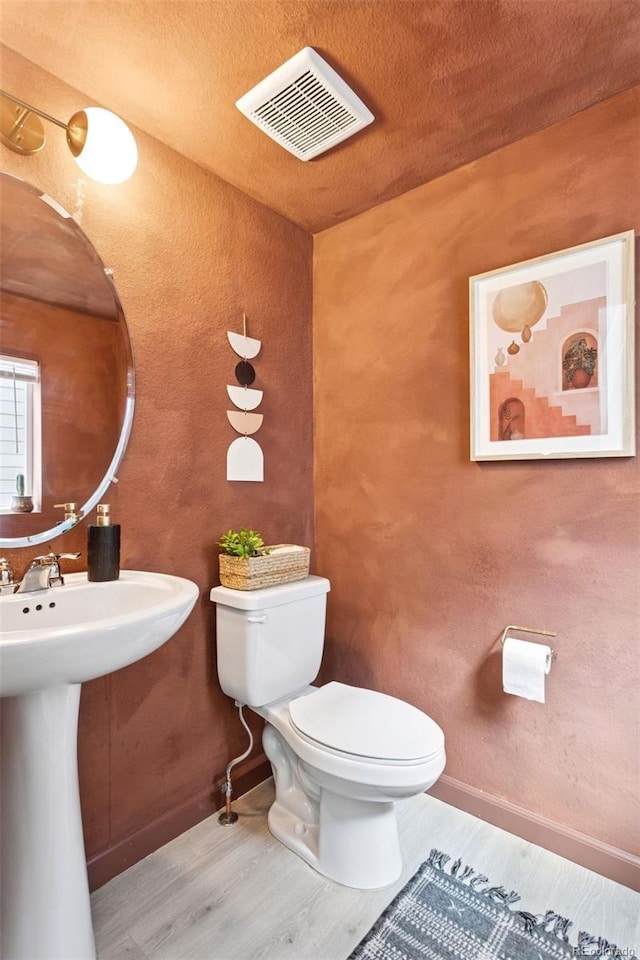 8057 Monte Vista Cir, Littleton, CO 80125 - half bath featuring toilet, wood finished floors, and a textured ceiling