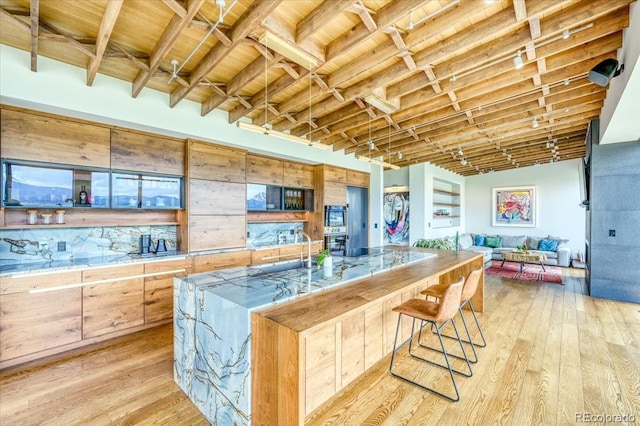421 Z Rd, Silverthorne, CO 80498 - kitchen with light wood finished floors, open floor plan, a kitchen breakfast bar, a large island with sink, and wood ceiling