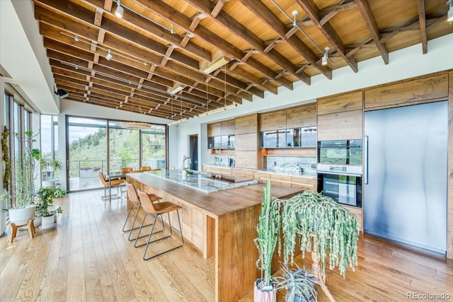 421 Z Rd, Silverthorne, CO 80498 - kitchen with light wood-style floors, a spacious island, a breakfast bar area, wooden ceiling, and light countertops