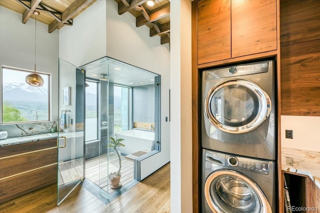 421 Z Rd, Silverthorne, CO 80498 - laundry area featuring stacked washer and clothes dryer, wooden ceiling, wood finished floors, plenty of natural light, and a high ceiling