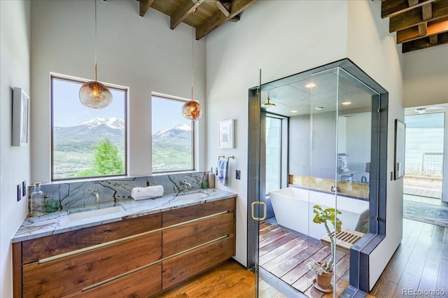421 Z Rd, Silverthorne, CO 80498 - bathroom with a freestanding tub, a towering ceiling, hardwood / wood-style flooring, tasteful backsplash, and double vanity