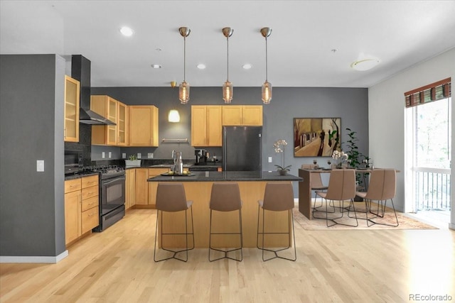 1438 Little Raven St Unit 201, Denver, CO 80202 - kitchen with freestanding refrigerator, black gas range, light brown cabinetry, wall chimney range hood, and a kitchen island
