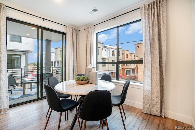 dining area with light hardwood / wood-style flooring and a wealth of natural light