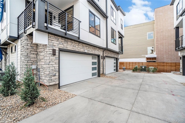 view of side of home featuring a garage and a balcony