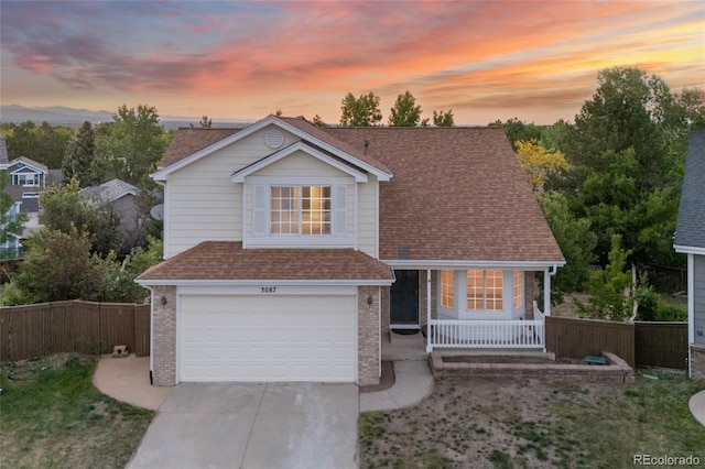 3087 Deer Creek Trl, Highlands Ranch, CO 80129 - view of front of house featuring a garage, covered porch, brick siding, and driveway