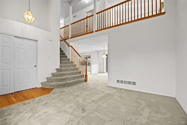 3087 Deer Creek Trl, Highlands Ranch, CO 80129 - carpeted entryway with high vaulted ceiling, stairs, and baseboards