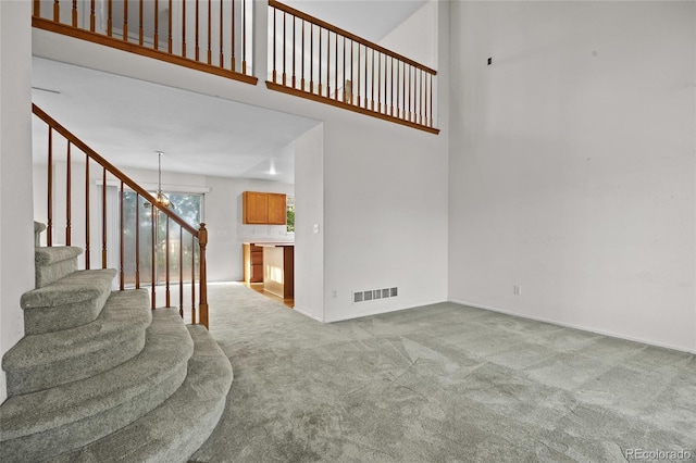 3087 Deer Creek Trl, Highlands Ranch, CO 80129 - staircase featuring carpet, a towering ceiling, and baseboards