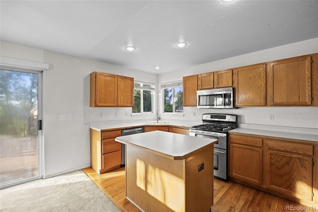 3087 Deer Creek Trl, Highlands Ranch, CO 80129 - kitchen with stainless steel appliances, brown cabinetry, light countertops, a center island, and a sink