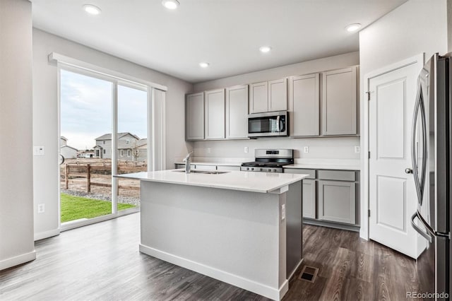 14440 Ranch St, Mead, CO 80504 - kitchen with gray cabinets, appliances with stainless steel finishes, dark wood-type flooring, light countertops, and a kitchen island with sink