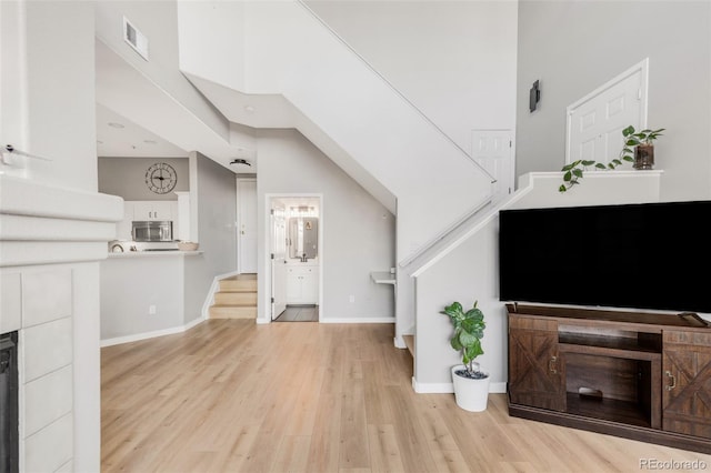 living room with light hardwood / wood-style flooring and a high ceiling