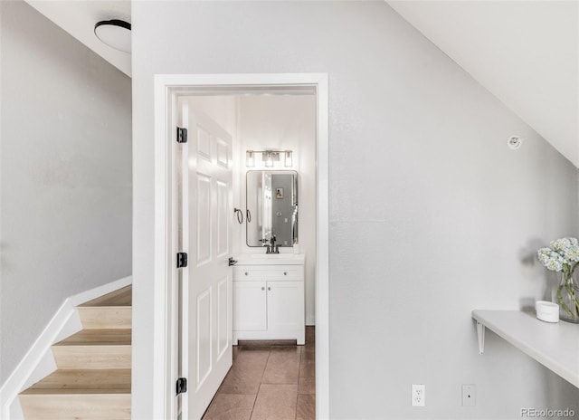 hall with sink and tile patterned floors