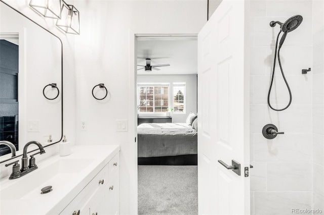 bathroom with vanity, ceiling fan, and a tile shower