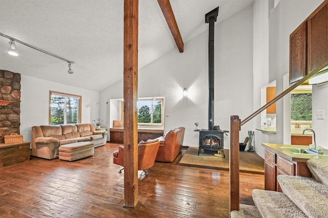 2169 Vigilante Ave, Bailey, CO 80421 - living area featuring a wood stove, hardwood / wood-style flooring, beamed ceiling, and high vaulted ceiling