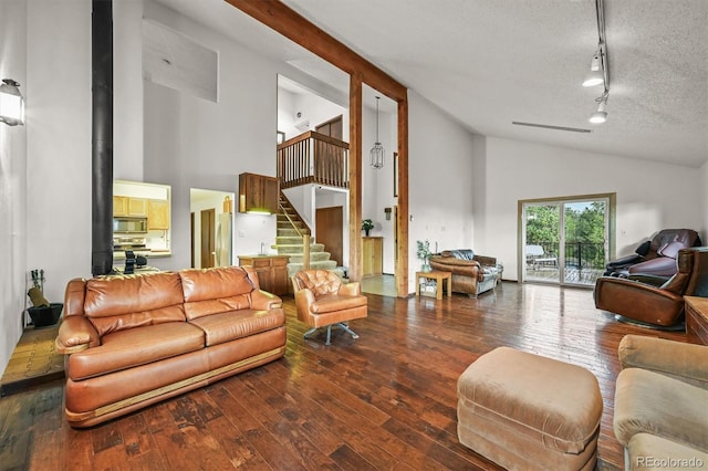 2169 Vigilante Ave, Bailey, CO 80421 - living area featuring high vaulted ceiling, rail lighting, hardwood / wood-style flooring, stairs, and a textured ceiling