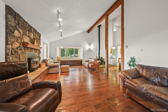 2169 Vigilante Ave, Bailey, CO 80421 - living room with lofted ceiling, a textured ceiling, hardwood / wood-style flooring, a fireplace, and track lighting