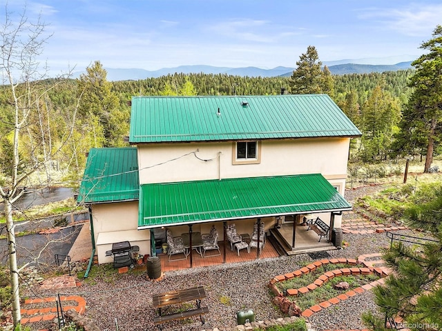 2169 Vigilante Ave, Bailey, CO 80421 - back of house featuring stucco siding, a view of trees, and a metal roof