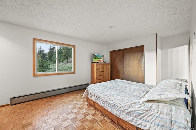 2169 Vigilante Ave, Bailey, CO 80421 - bedroom with a baseboard radiator, a closet, and a textured ceiling
