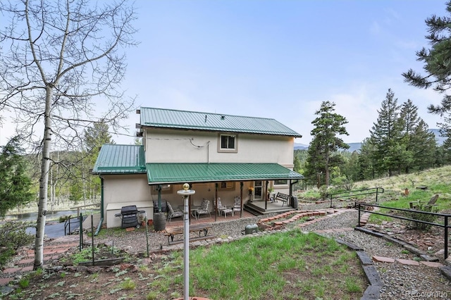 2169 Vigilante Ave, Bailey, CO 80421 - rear view of property with a metal roof, stucco siding, and covered porch