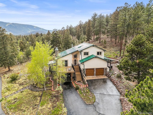 2169 Vigilante Ave, Bailey, CO 80421 - view of front of house featuring driveway, stairs, a wooded view, stucco siding, and an attached garage