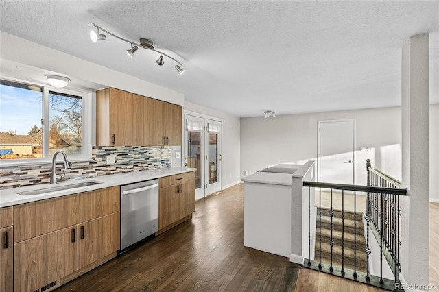 kitchen with dark wood-type flooring, french doors, sink, tasteful backsplash, and stainless steel dishwasher