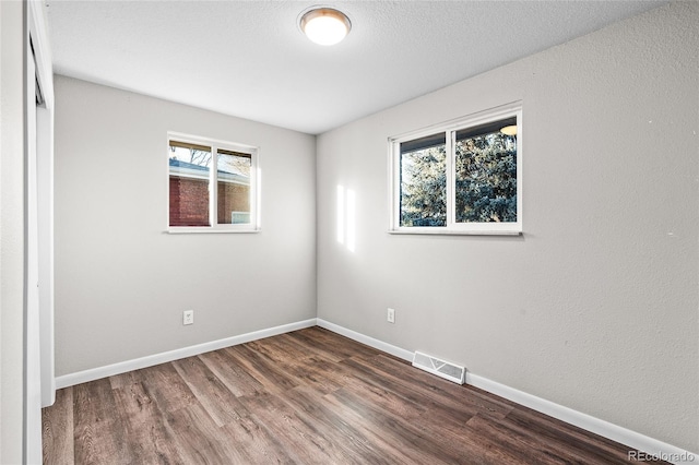 spare room with hardwood / wood-style flooring and a textured ceiling