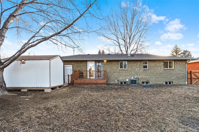 back of house featuring a shed, central AC, and a deck