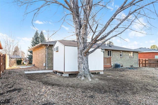 back of property featuring cooling unit and a shed