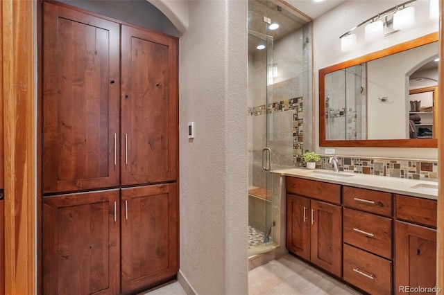 full bath featuring a textured wall, a sink, a closet, and a stall shower