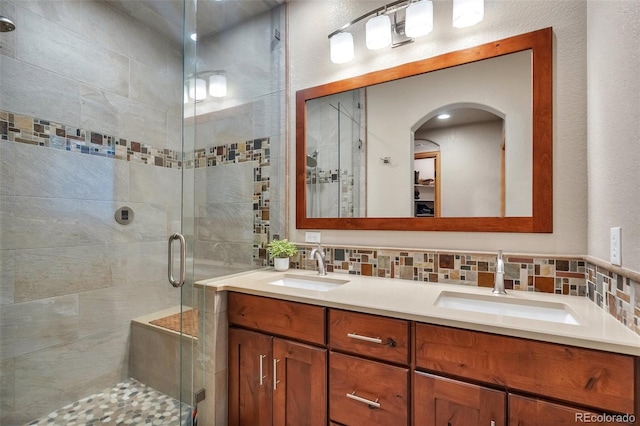 full bathroom featuring a shower stall, a sink, and double vanity