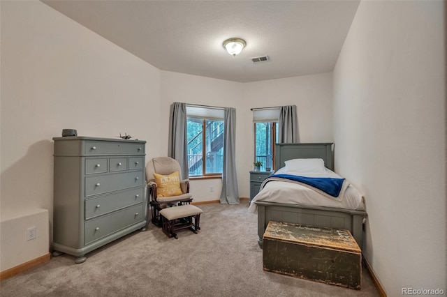 carpeted bedroom featuring baseboards and visible vents