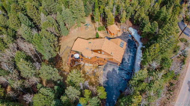 bird's eye view with a wooded view