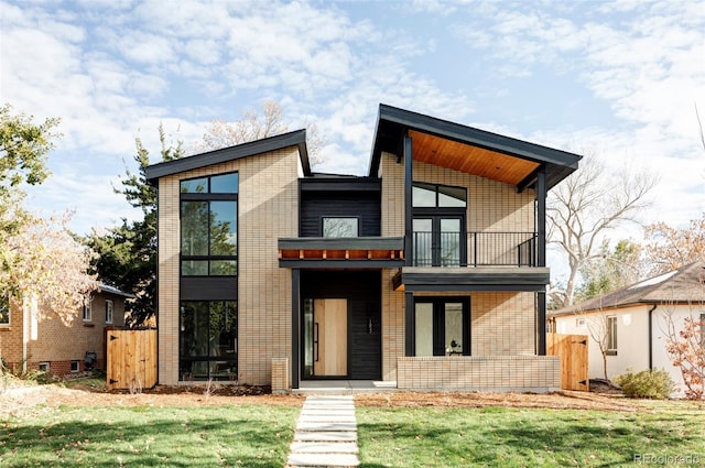 modern home with a balcony and a front lawn