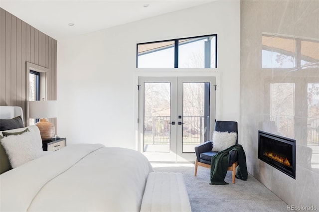 bedroom featuring access to outside, multiple windows, and a tiled fireplace