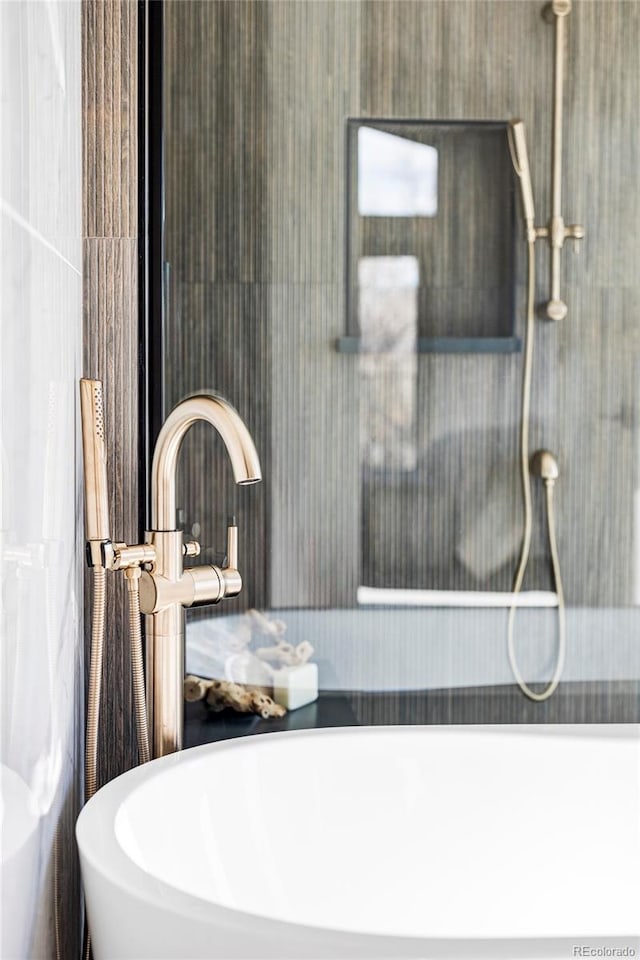 bathroom with a tub to relax in and sink