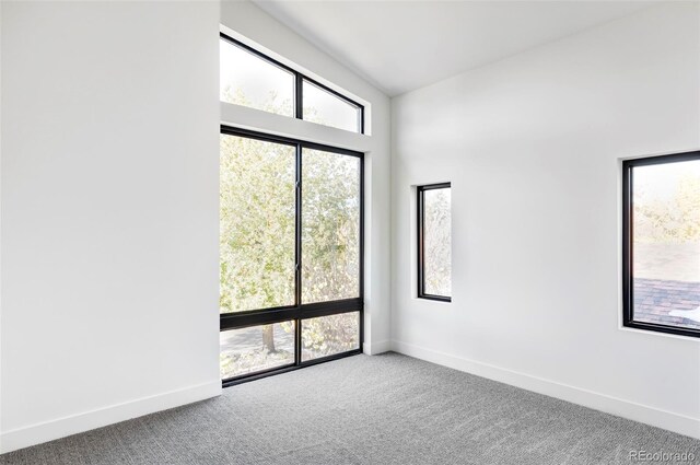 carpeted spare room with lofted ceiling