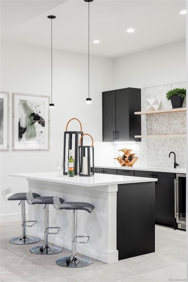 kitchen featuring tasteful backsplash, light tile patterned floors, beverage cooler, and decorative light fixtures